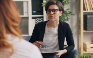 Coach consulting with client on value-based pricing in NLP and hypnotherapy.