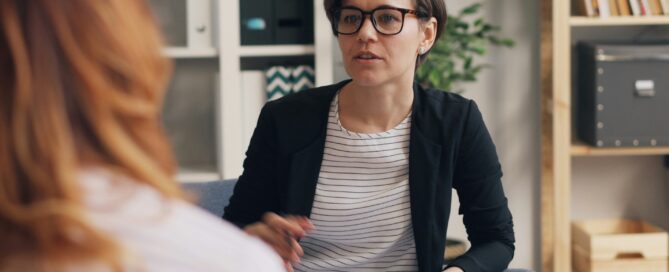 Coach consulting with client on value-based pricing in NLP and hypnotherapy.